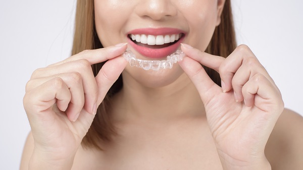 Donna mostra il suo apparecchio Invisalign.